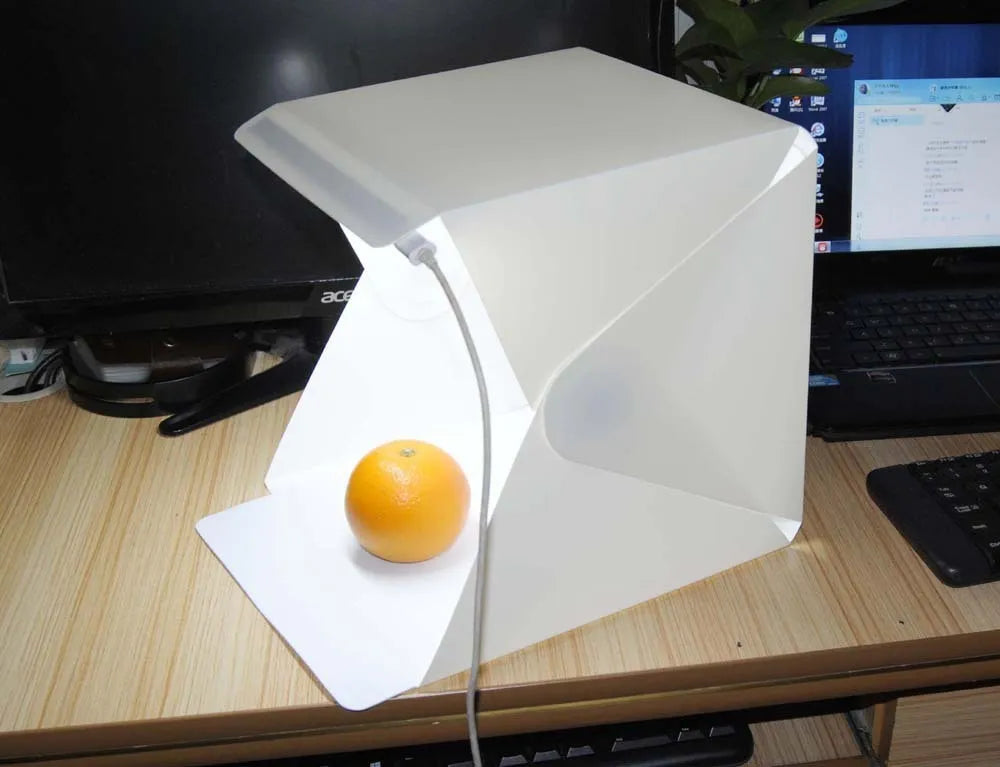 40cm folding photography light box with LED ring light and multiple coloured background cloths setup for product shooting.