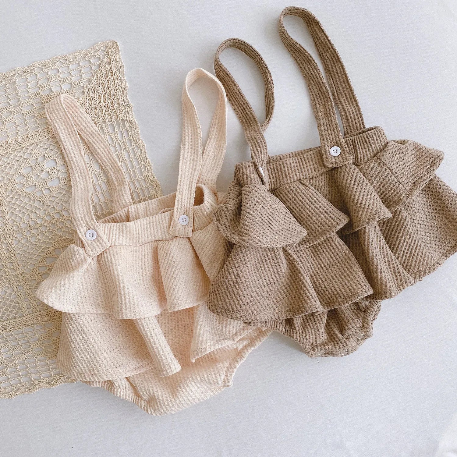 Apricot coloured baby romper with pleated lotus leaf design and sling climbing suit style for 0-2 year olds.