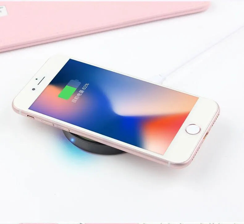 Square Qi wireless phone charger base in six colour options on a wooden desk.