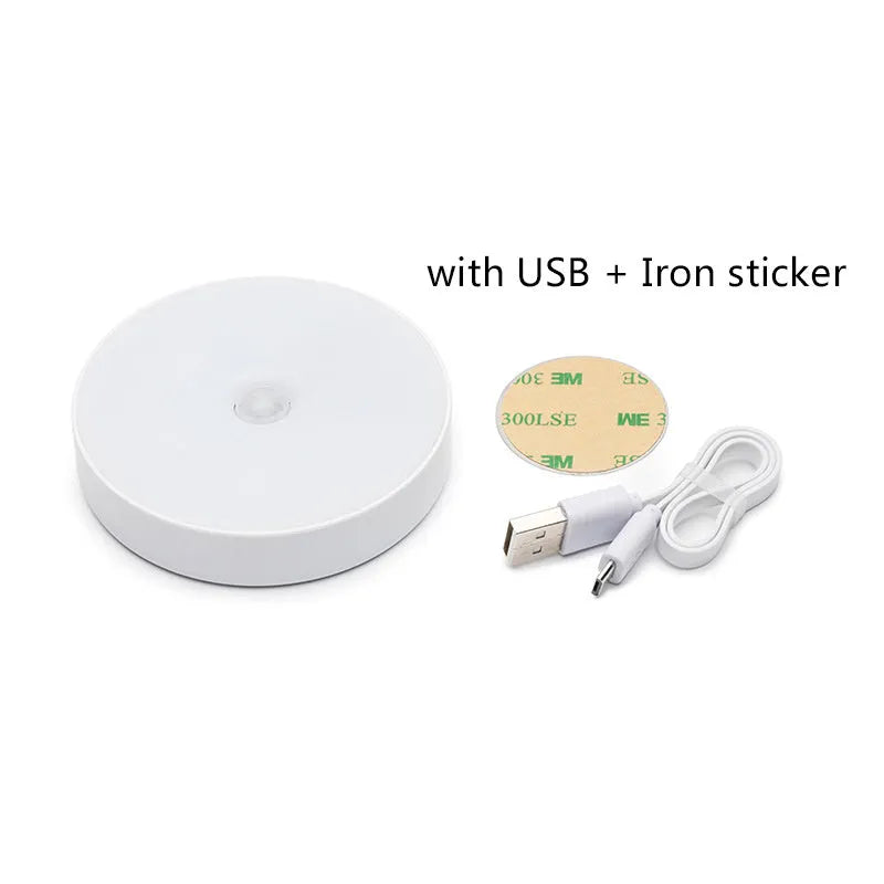 Small round beige and white LED motion sensor night light with USB charging cable.
