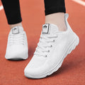 Women's high top casual flat shoe with cross bind strap and back lacing in white.