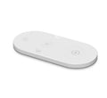 Black circular 15W wireless charging pad with USB port on desk next to phone