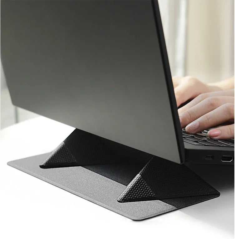 Blue or grey portable foldable laptop cooling stand bracket with anti-slip pads on a flat surface.