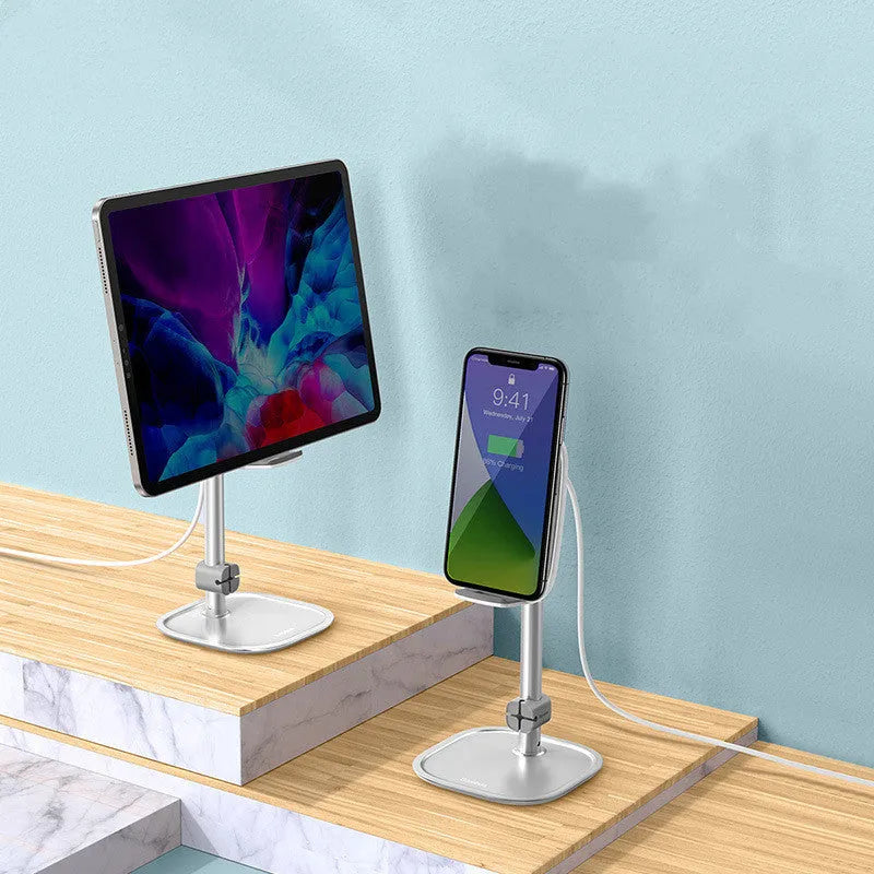 Baseus 15W wireless charger stand with adjustable tablet holder in silver, holding a smartphone on a desktop