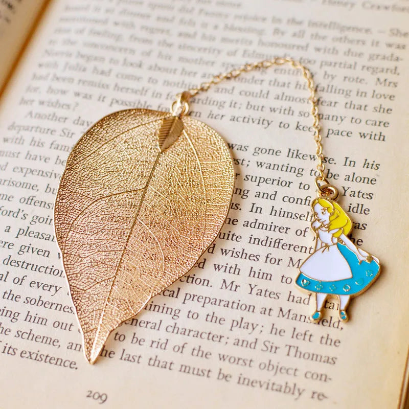 KC alloy bookmark charms showing Alice, Rabbit, Clock, and Leaf designs on kraft cardboard packaging