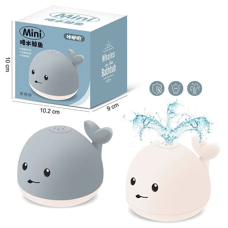 Grey and white cartoon whale bath toy floating in water with spray fountain and LED lights
