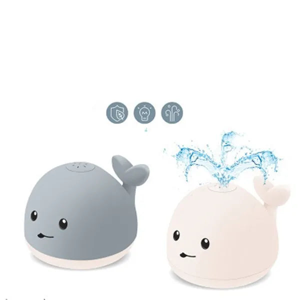 Grey and white cartoon whale bath toy floating in water with spray fountain and LED lights