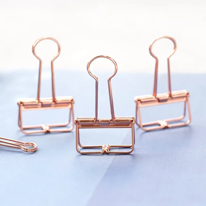 Rose gold metal binder set showing small and large folders for ticket and document organisation.