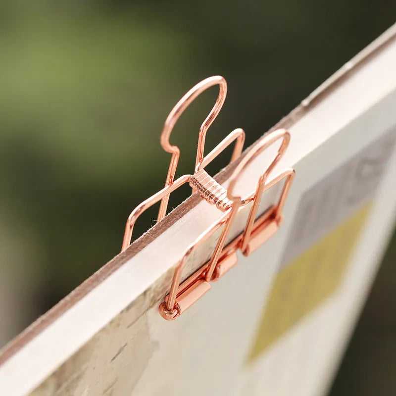 Rose gold metal binder set showing small and large folders for ticket and document organisation.