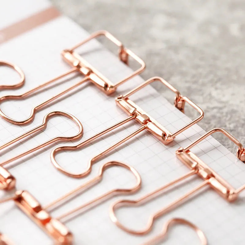 Rose gold metal binder set showing small and large folders for ticket and document organisation.