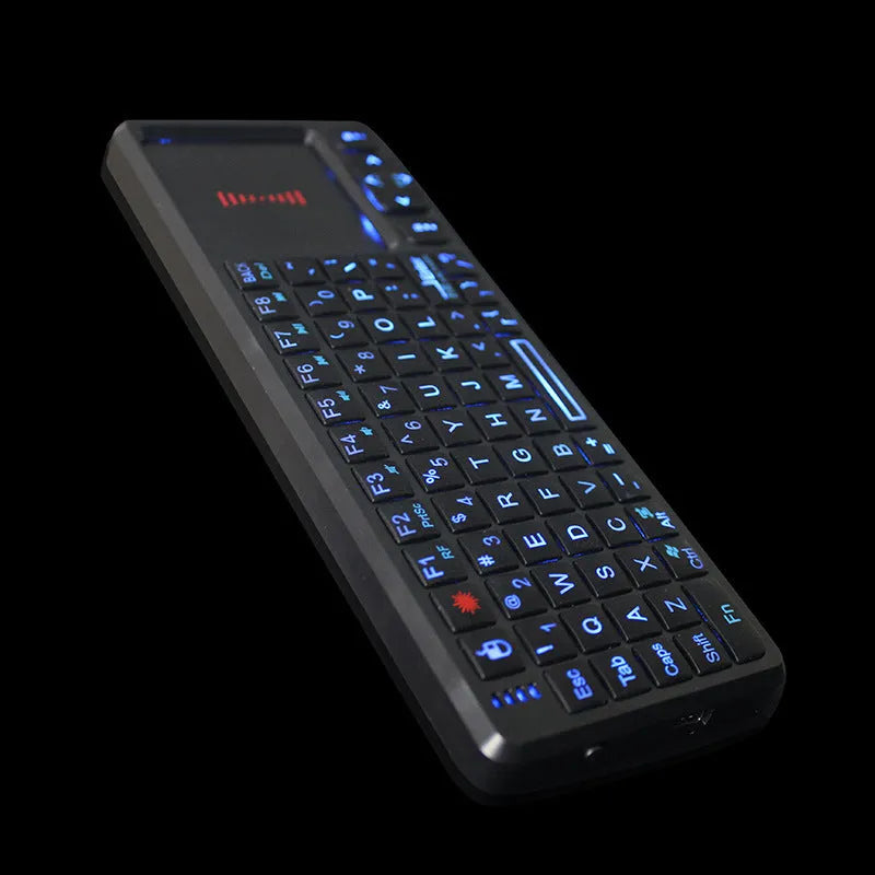Black wireless mini keyboard with touch screen and matching laser mouse on a desk.