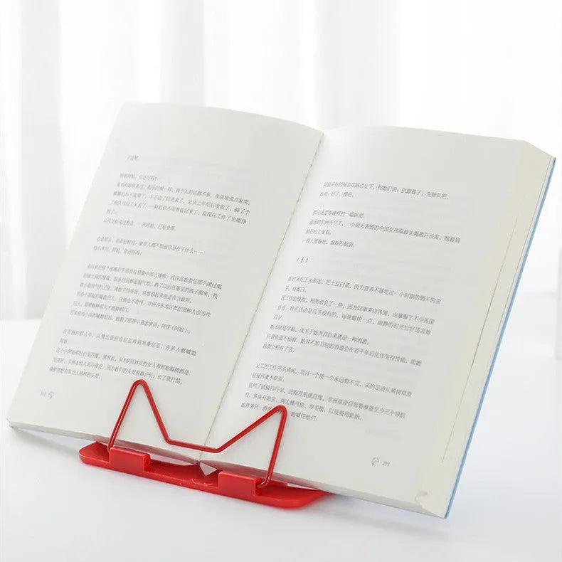Multifunctional metal reading frame in red, green, and blue colours on a desk with a book.