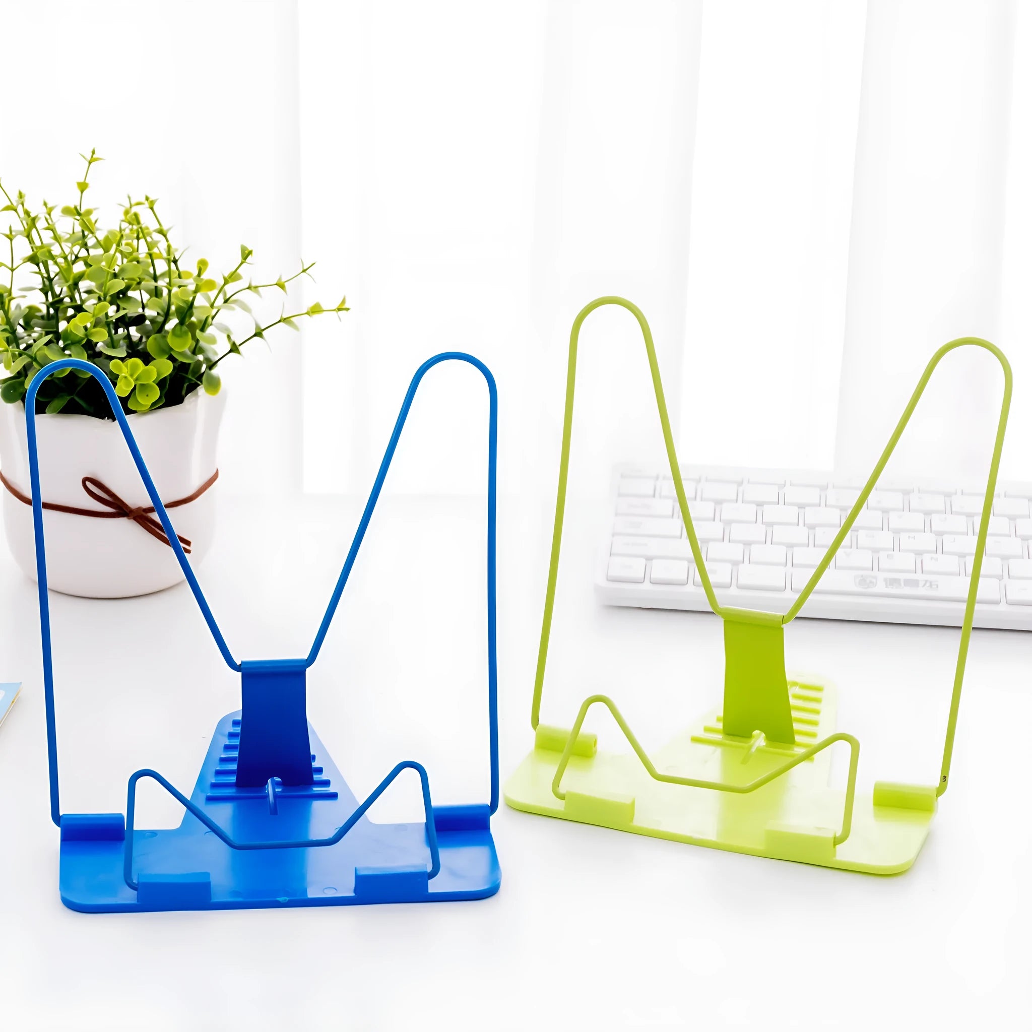 Multifunctional metal reading frame in red, green, and blue colours on a desk with a book.