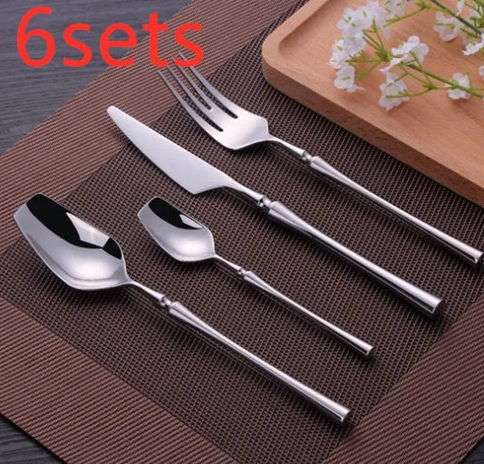 Stainless steel cutlery set with gold finish including knife, fork, spoon, and teaspoon on table