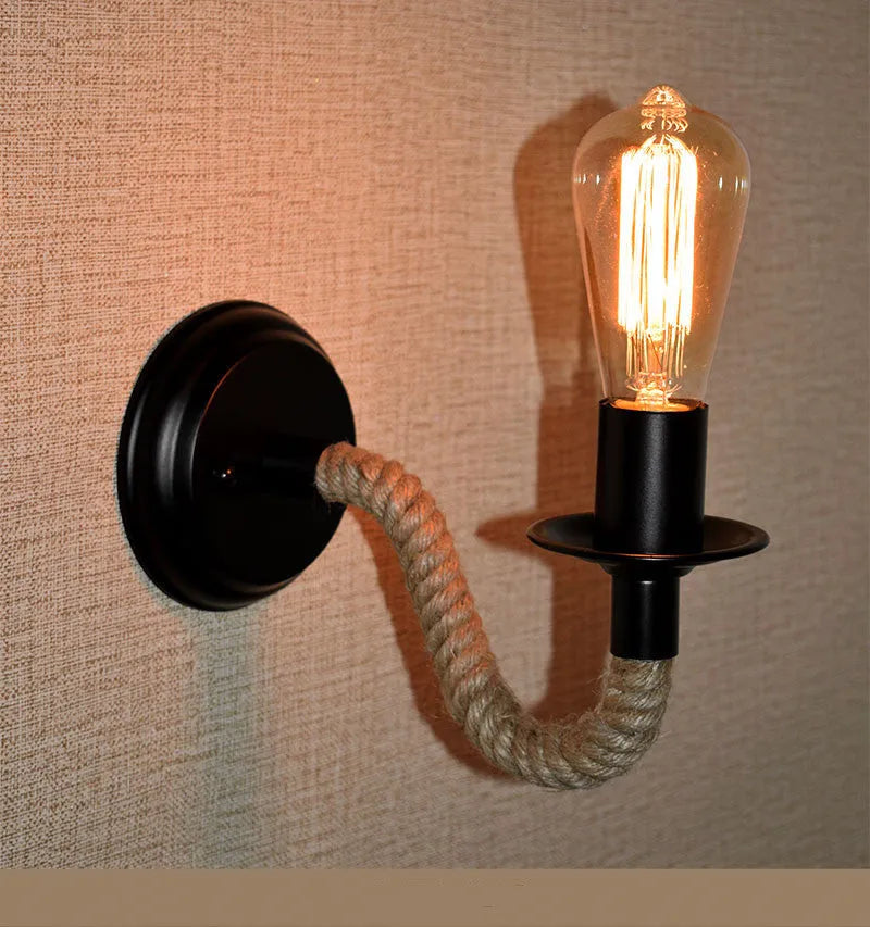 Retro creative wrought iron twine wall lamp in black with handmade hemp rope wrap on a bedside table