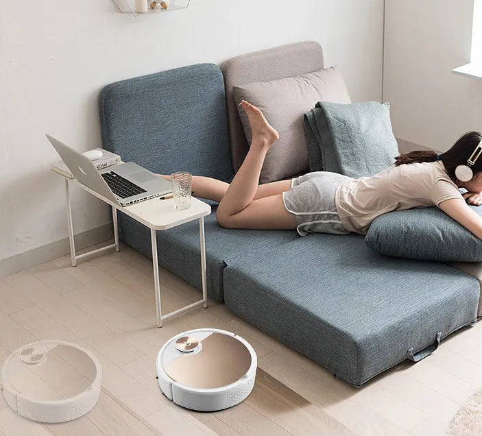 Silver or golden intelligent robot vacuum cleaner with remote control on a hardwood floor