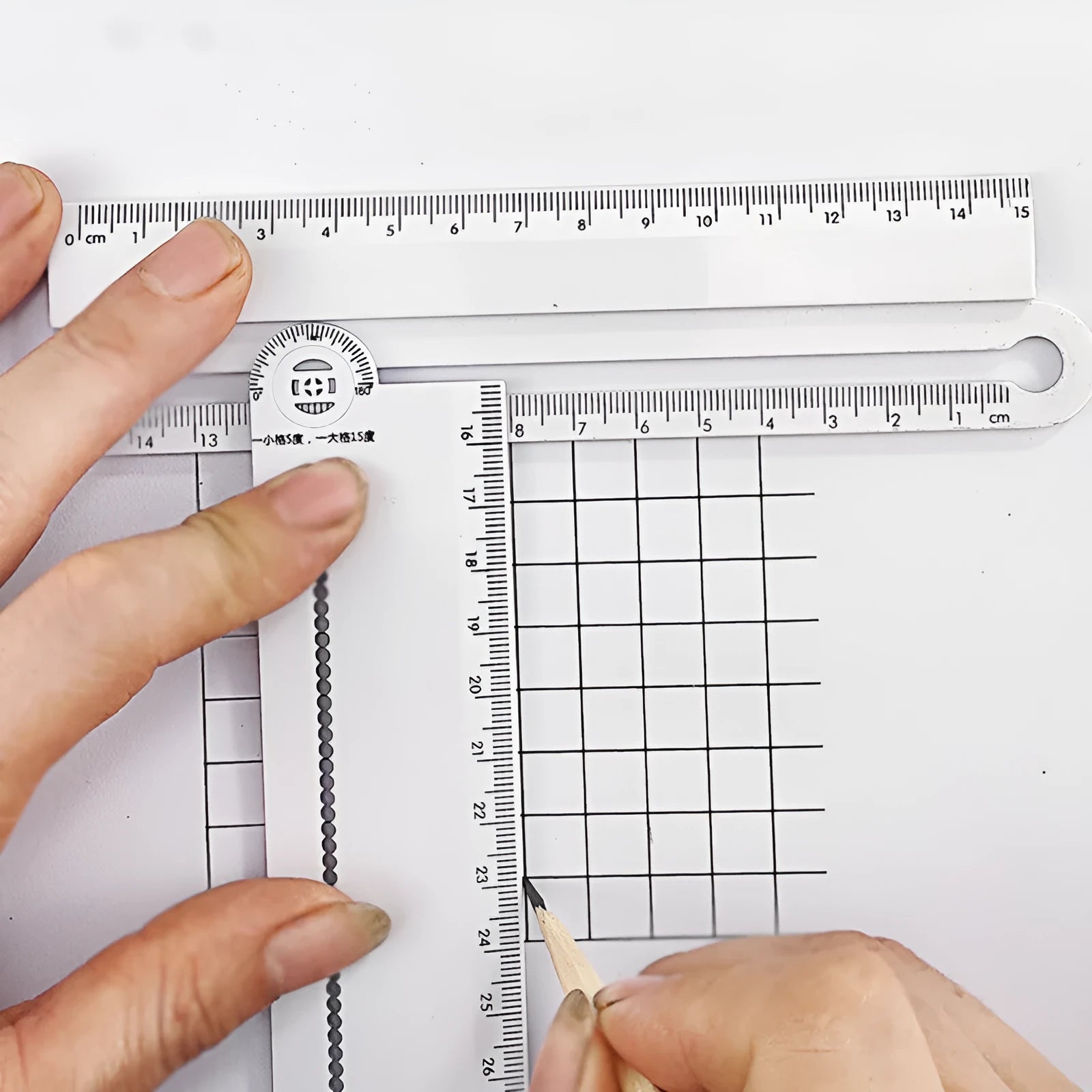 White plastic multi-function ruler measuring 30 cm in length on a flat surface.