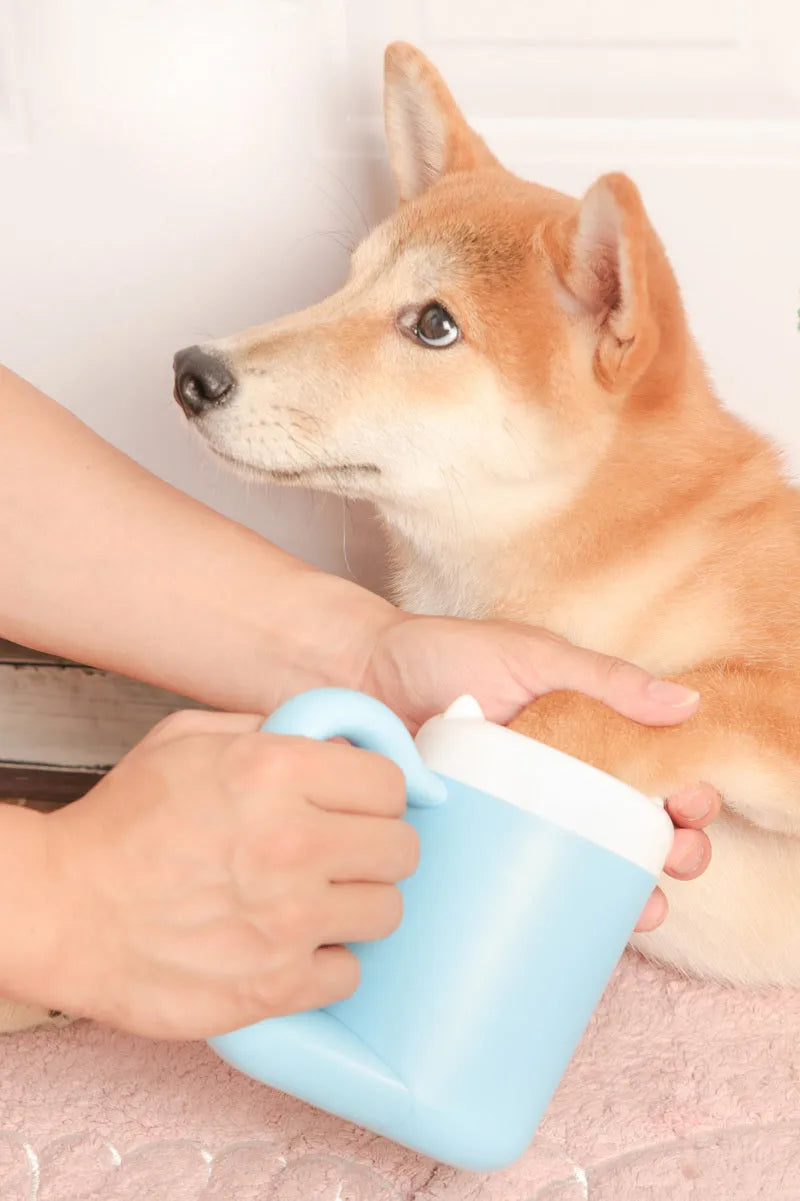 Blue pet paw cleaning cup with silicone brush for small dogs and cats on white background