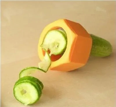 Yellow and green plastic spiral vegetable cutter for slicing cucumbers on a kitchen counter.