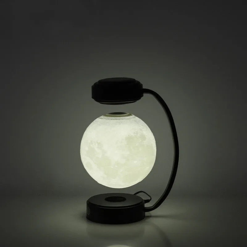 Black magnetic levitation moon lamp floating above base with touch control and colour-changing LED lights