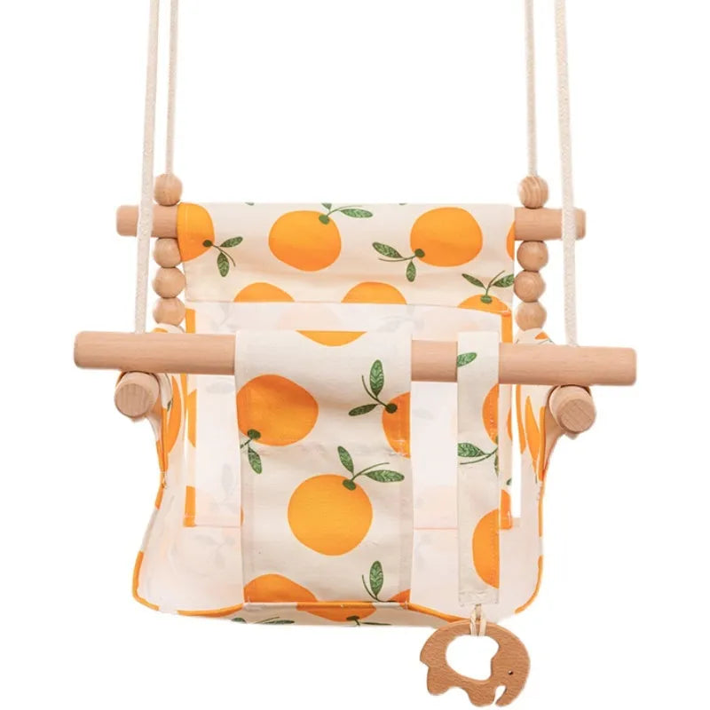 Natural beige cotton canvas baby swing chair with wooden seat and decorative tassel pattern, hanging indoors.