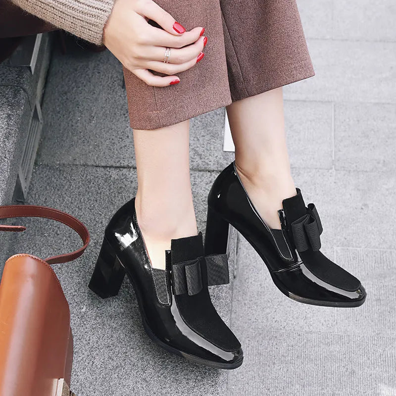 Black patent leather women's high heel shoes with a thick block heel and square toe.