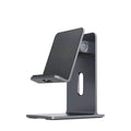 Alloy universal mobile phone and tablet stand in dark space grey colour on a wooden desk.