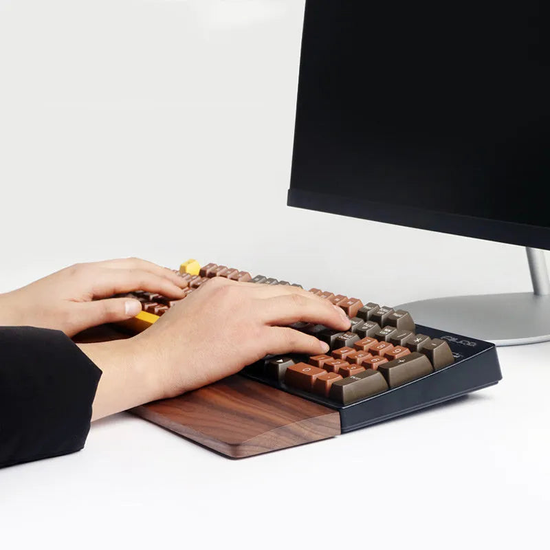 Solid walnut wood wrist rest for mechanical keyboard on a wooden desk