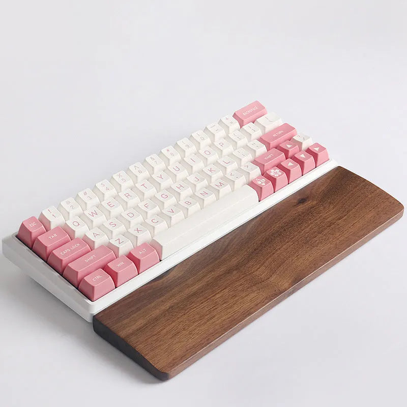 Solid walnut wood wrist rest for mechanical keyboard on a wooden desk
