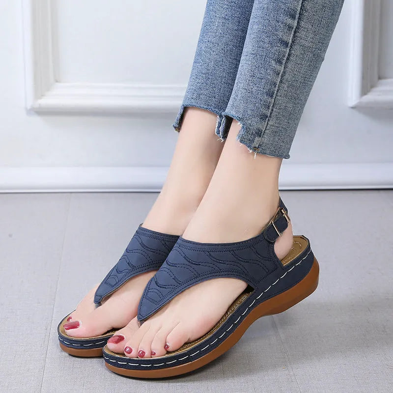 Women's red wedge heel sandals with an adjustable back strap buckle.