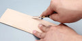 Professional hair thinning knife with leather handle, showing sectional cutting and wide shovel edges.