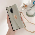 Pink imitation leather Huawei phone case with handbag pattern and gold chain, fitted to a phone.