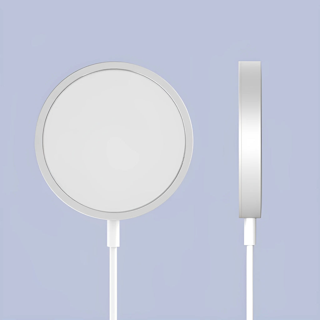 Silver metallic Magsafe magnetic wireless charger for iPhone on a wooden desk.
