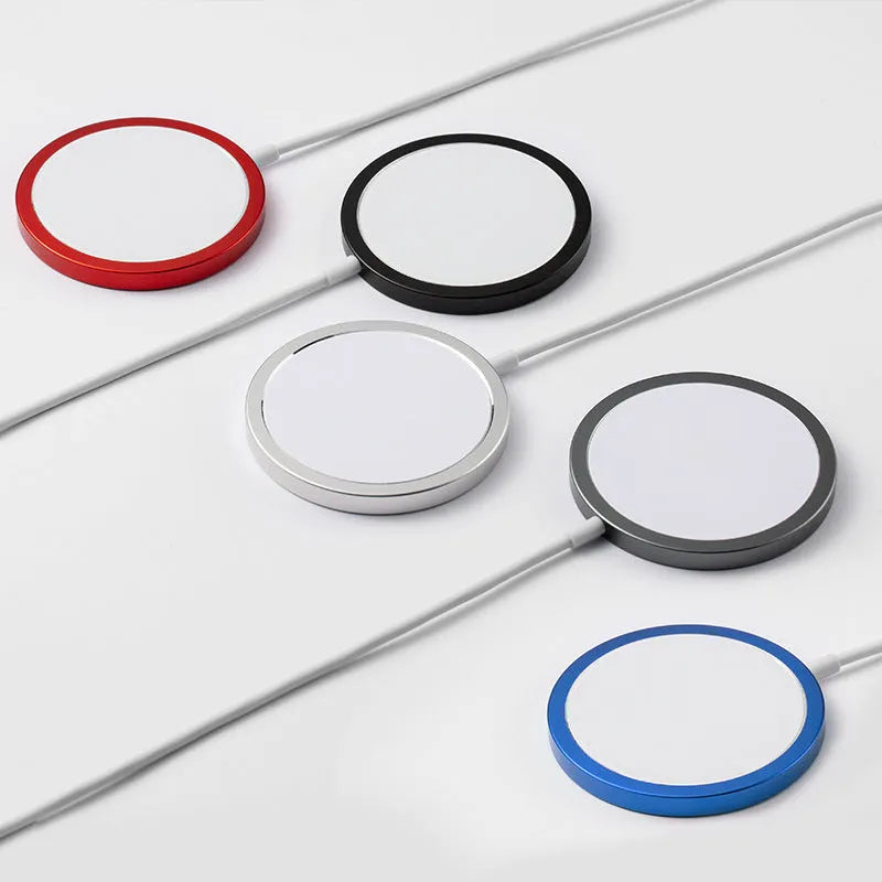 Silver metallic Magsafe magnetic wireless charger for iPhone on a wooden desk.