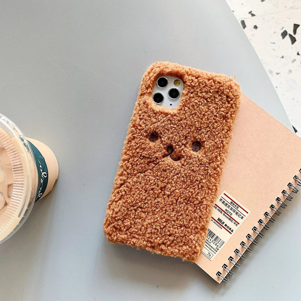 Soft brown TPU iPhone case with an embroidered plush cartoon bear face design on the back.
