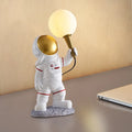 White astronaut desk lamp in three styles: seated, standing, and wall-mounted children's night light