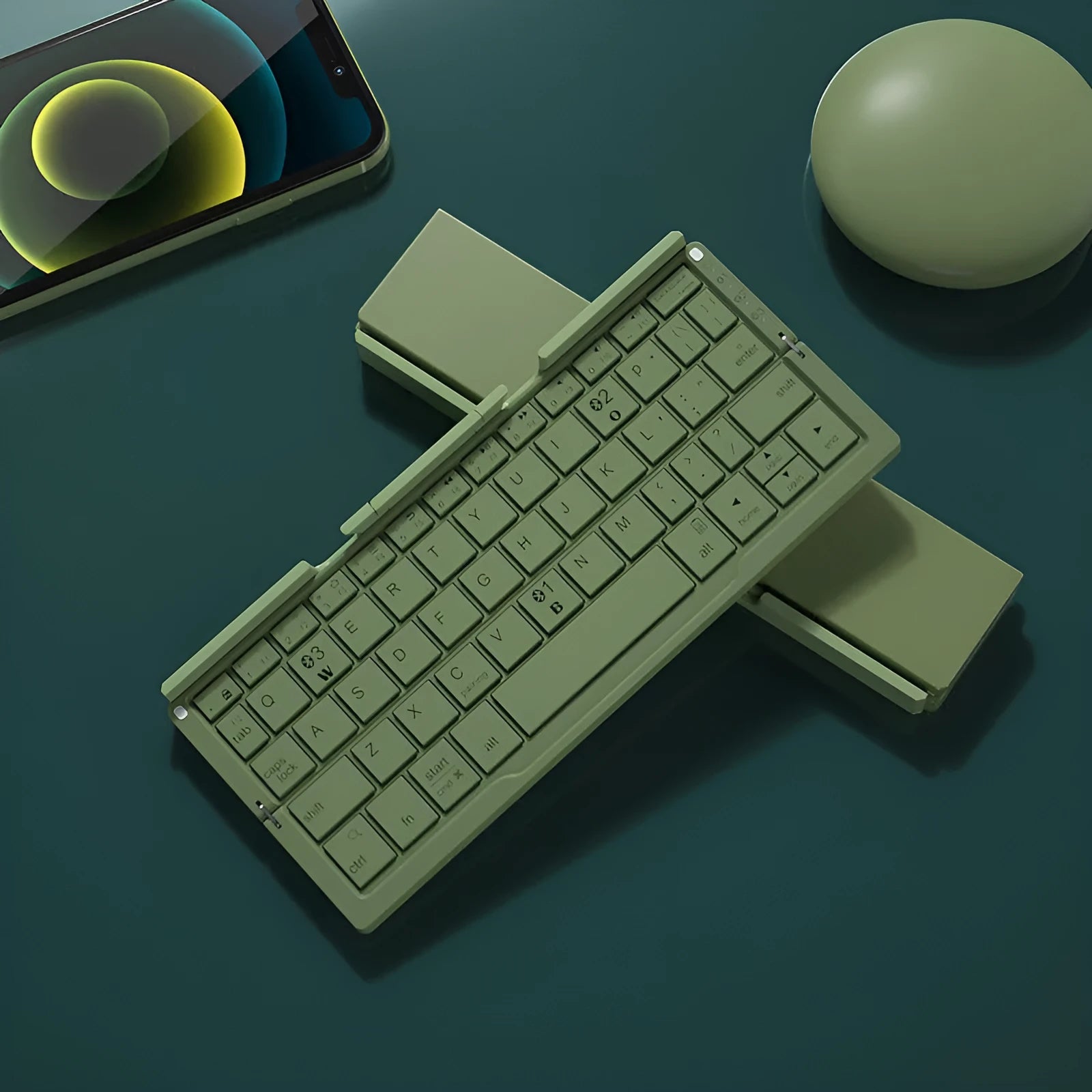 Folded aluminium Bluetooth keyboard showing compact size next to unfolded version with tablet on stand