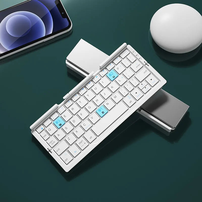 Folded aluminium Bluetooth keyboard showing compact size next to unfolded version with tablet on stand