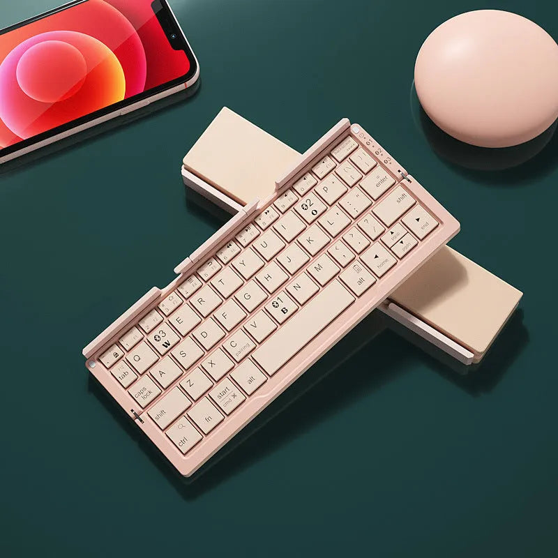Folded aluminium Bluetooth keyboard showing compact size next to unfolded version with tablet on stand