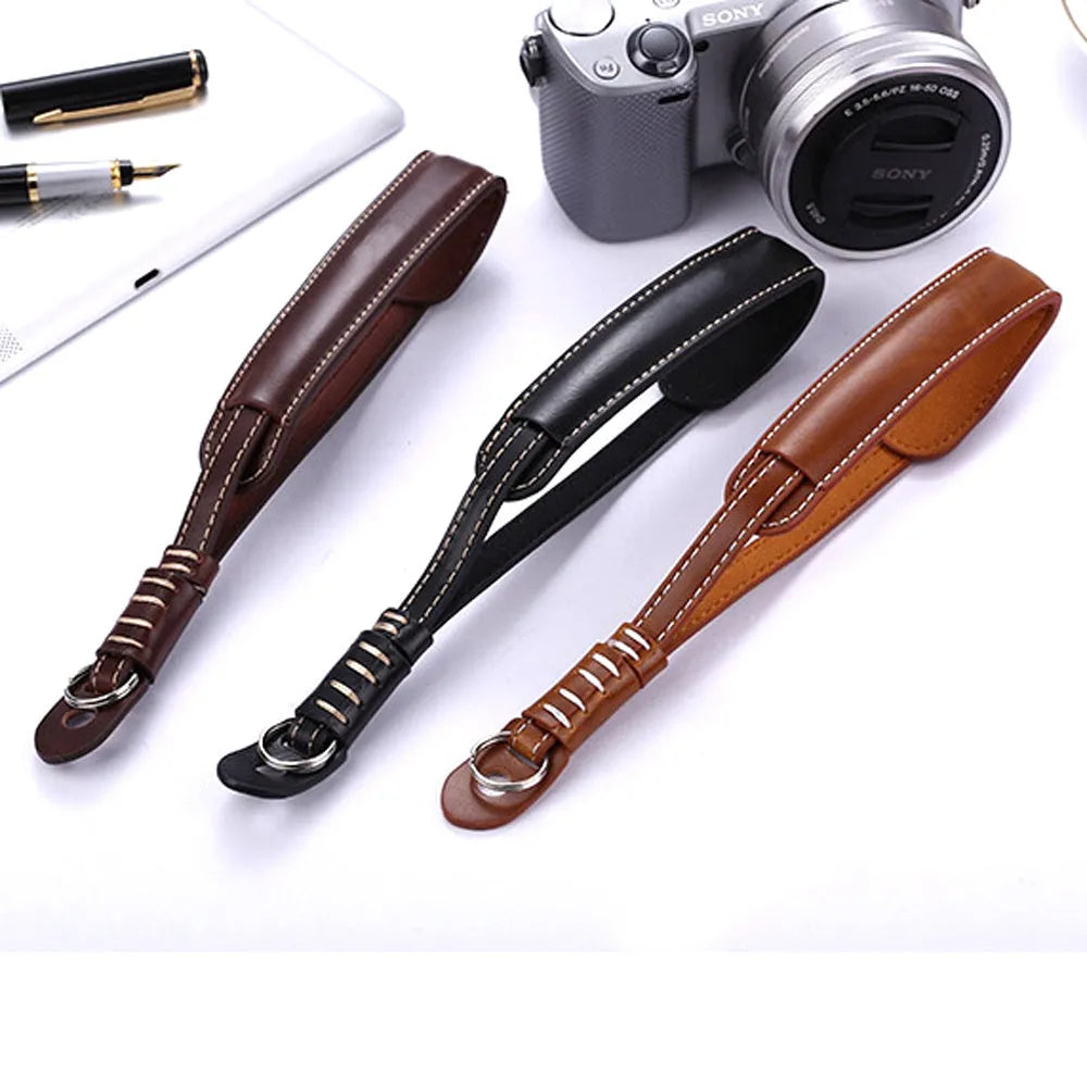 Adjustable black nylon wrist strap for digital cameras with metal slider buckle.