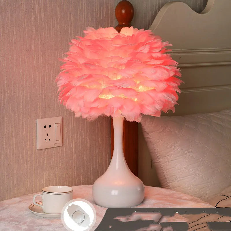White feather table lamp with hand-woven fur shade and iron base on a wooden bedside table.