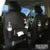 Black PU leather car storage hanging bag with multiple pockets on a car seat.