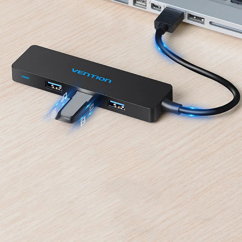 Black 4-port USB 3.0 hub with a short braided cable and nickel-plated connectors on a desk.