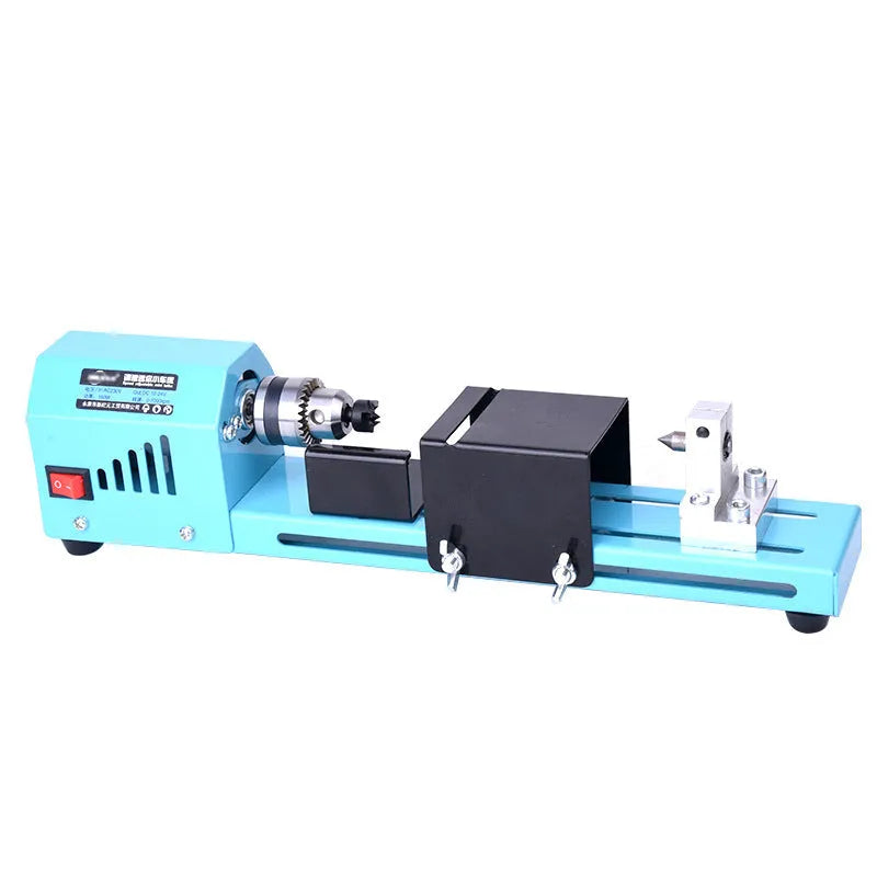 Blue mini DIY woodworking lathe with protective cover on desktop, 150W motor, steel chuck, and accessories