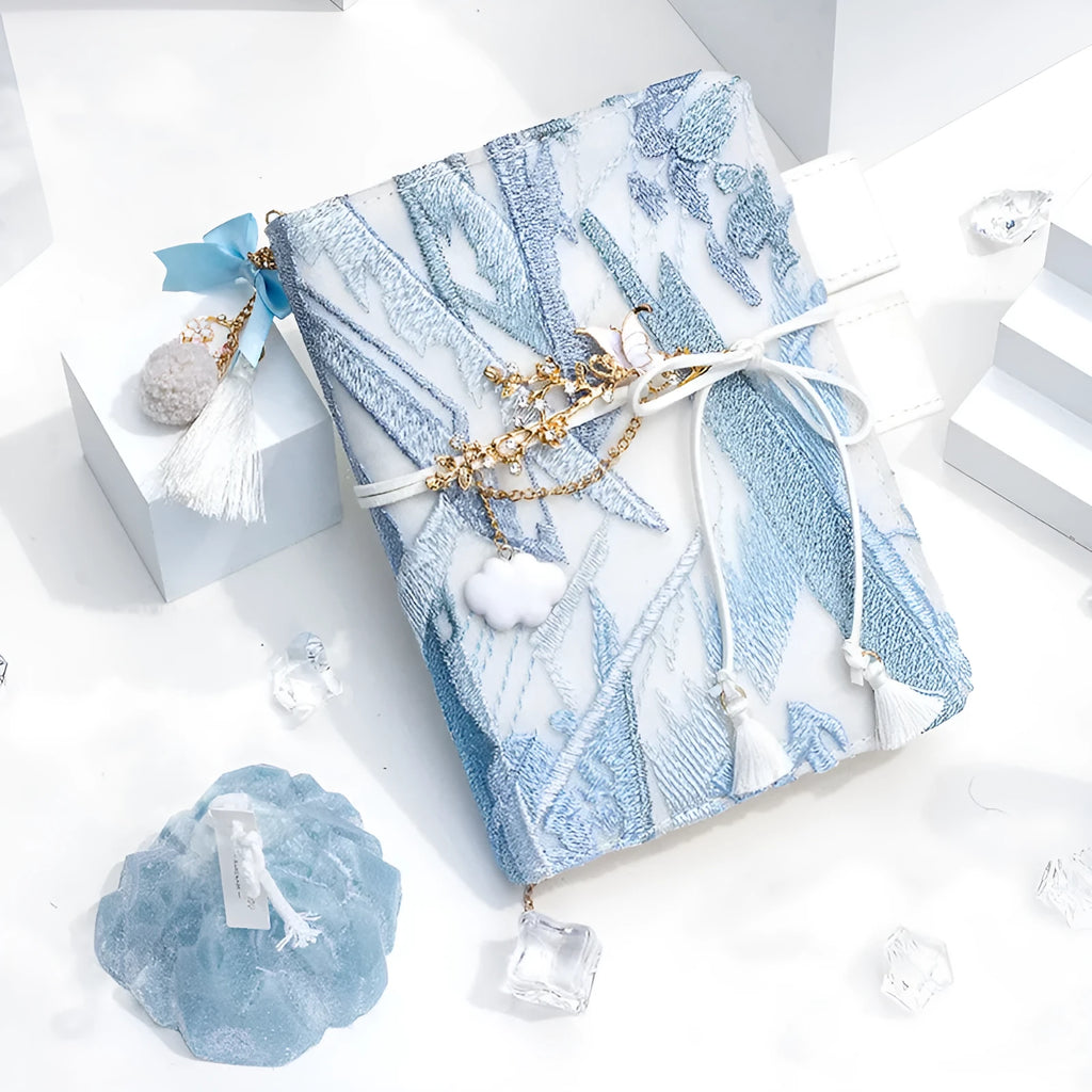 Glacier embroidery design on a fabric cover notebook lying open on a grid page.