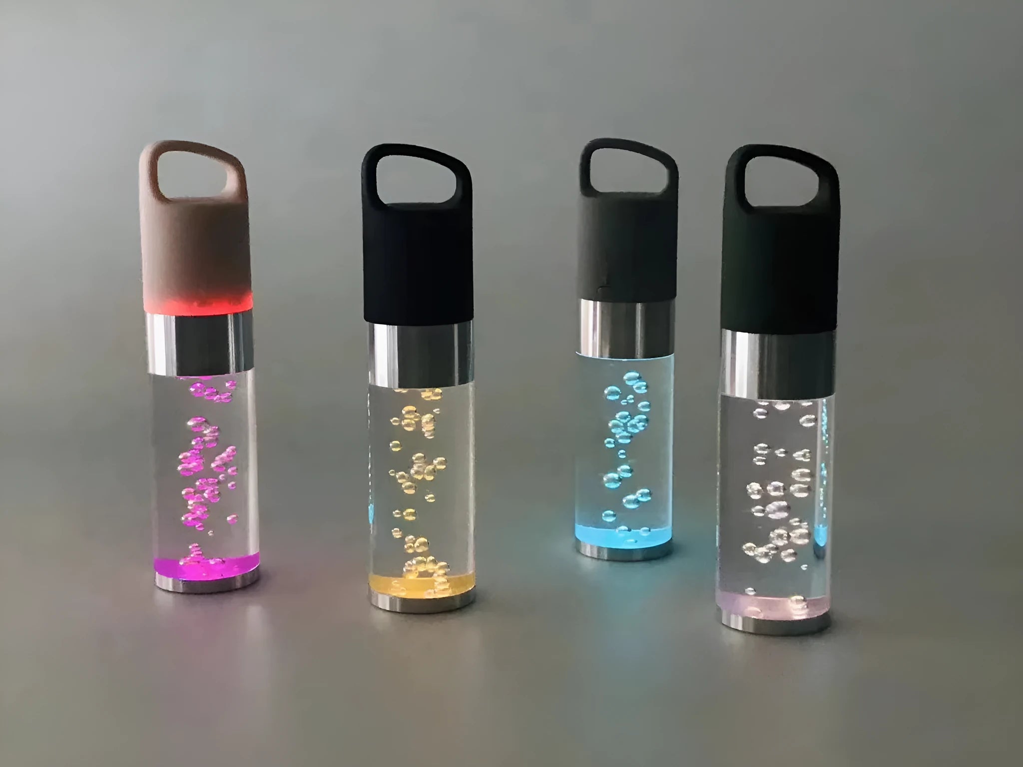 Compact colourful portable Bluetooth speaker with a crystal light in pink, black, silver grey, or green.