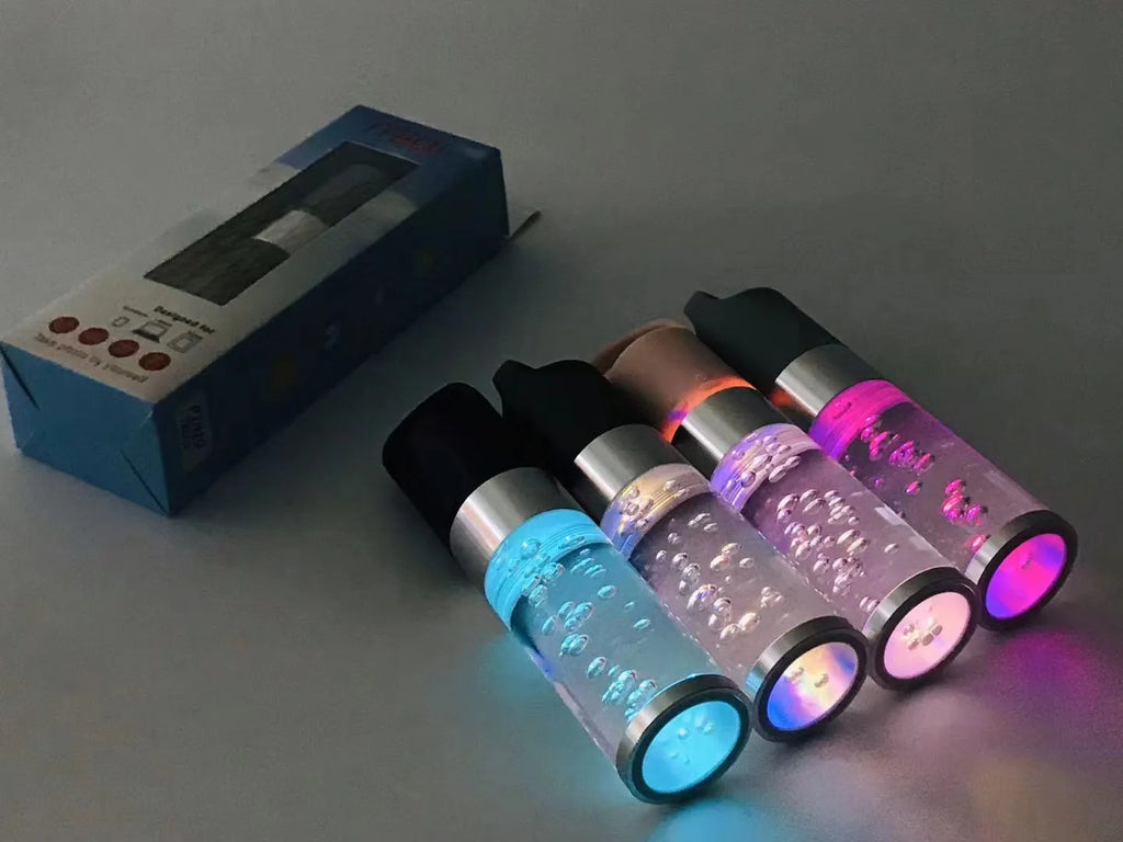 Compact colourful portable Bluetooth speaker with a crystal light in pink, black, silver grey, or green.