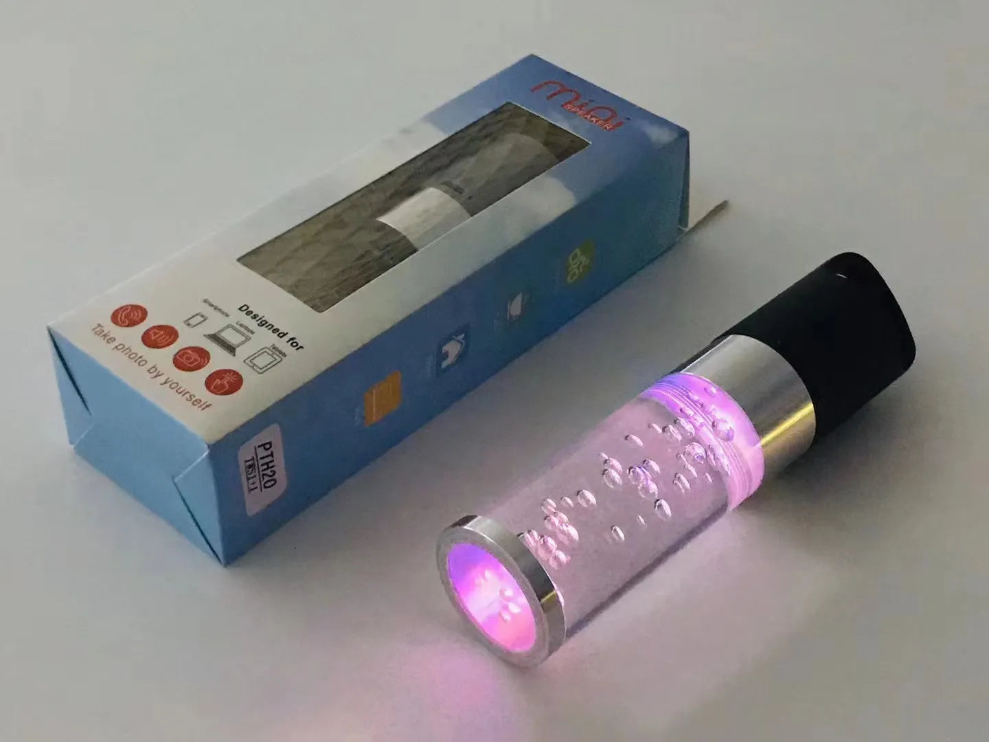 Compact colourful portable Bluetooth speaker with a crystal light in pink, black, silver grey, or green.