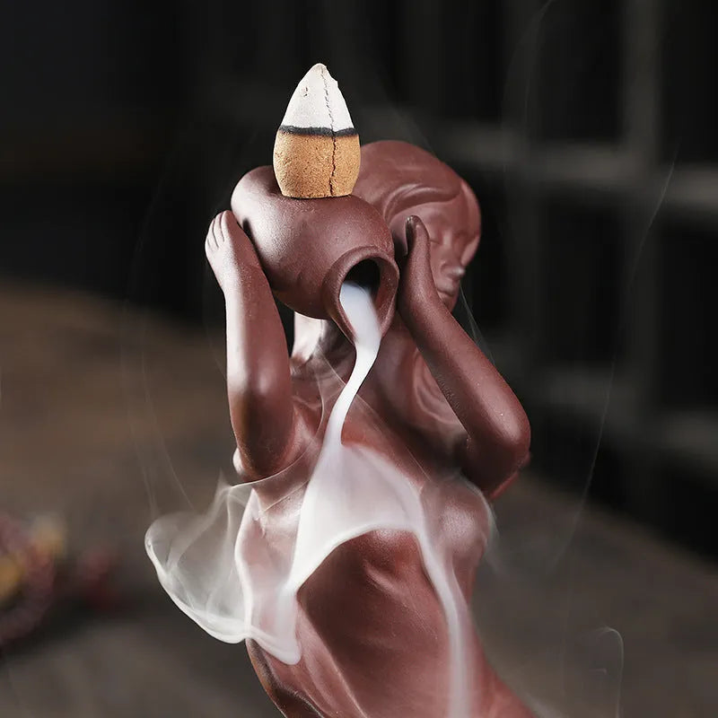 Red handmade ceramic snail-shaped backflow incense burner on a table