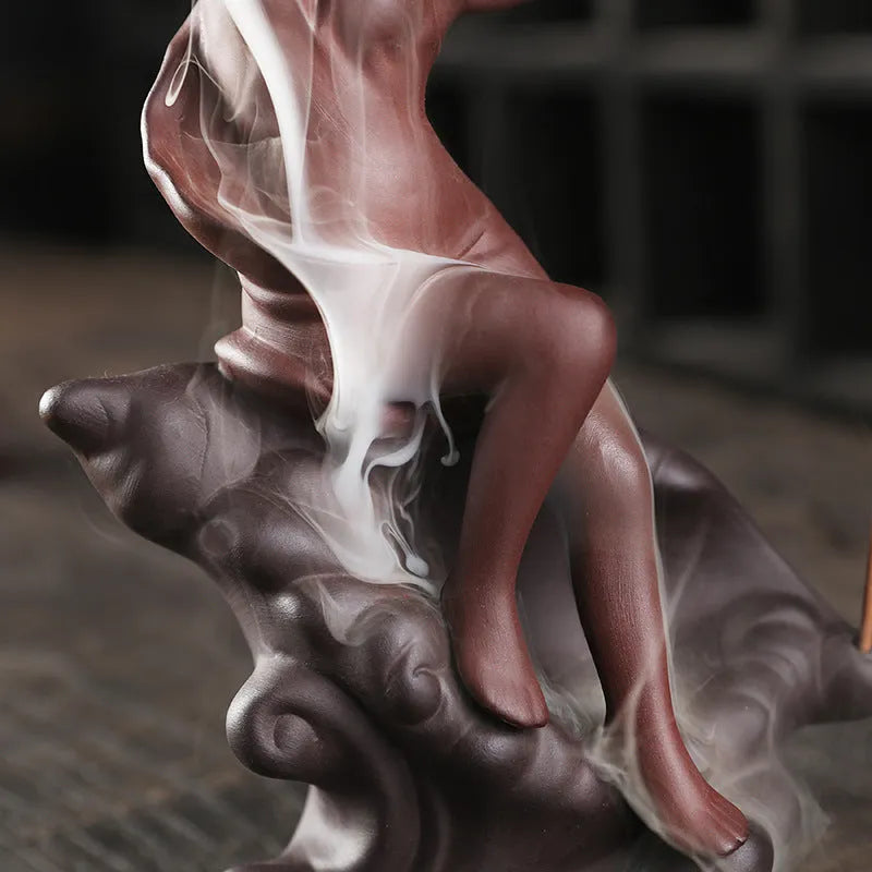 Red handmade ceramic snail-shaped backflow incense burner on a table